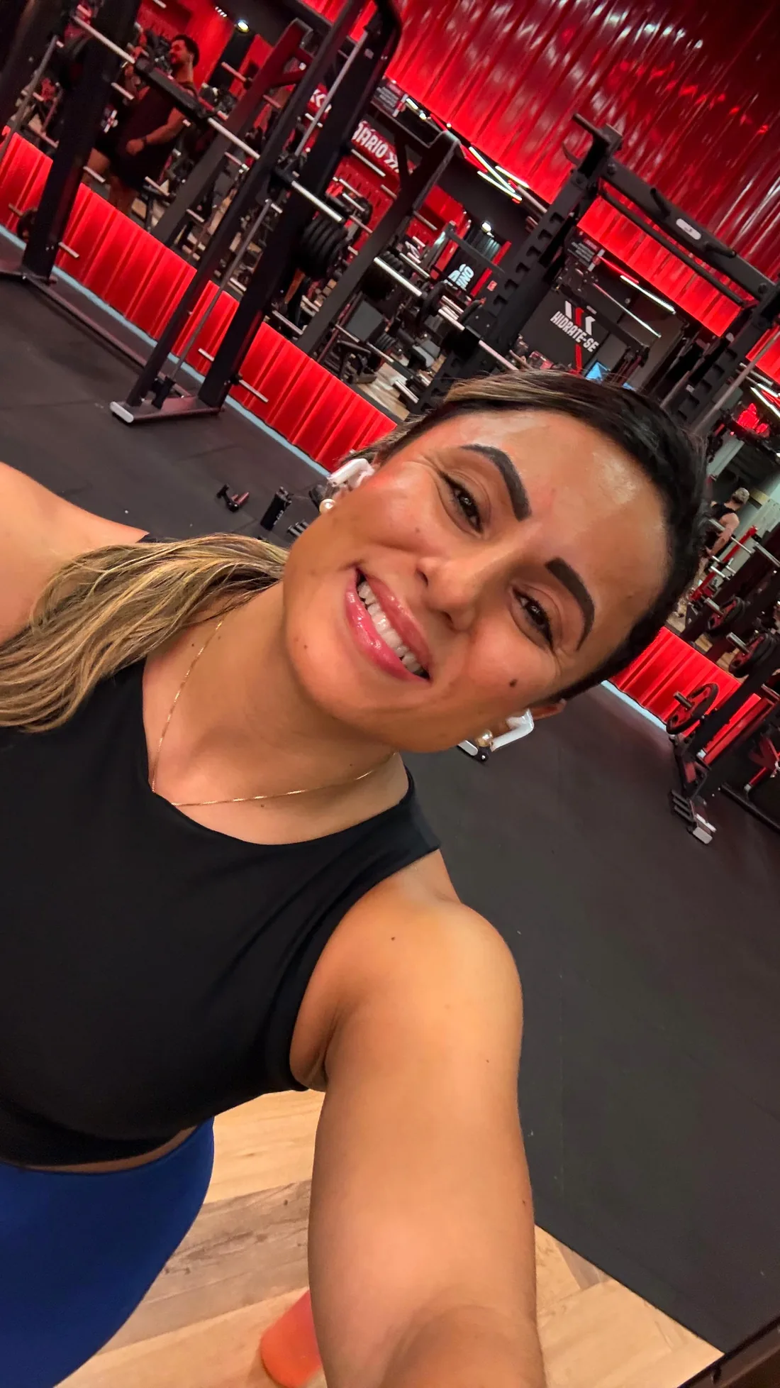 Monique Ribeiro sorrindo em selfie entre os aparelhos vermelhos da Gaviões Rio Branco