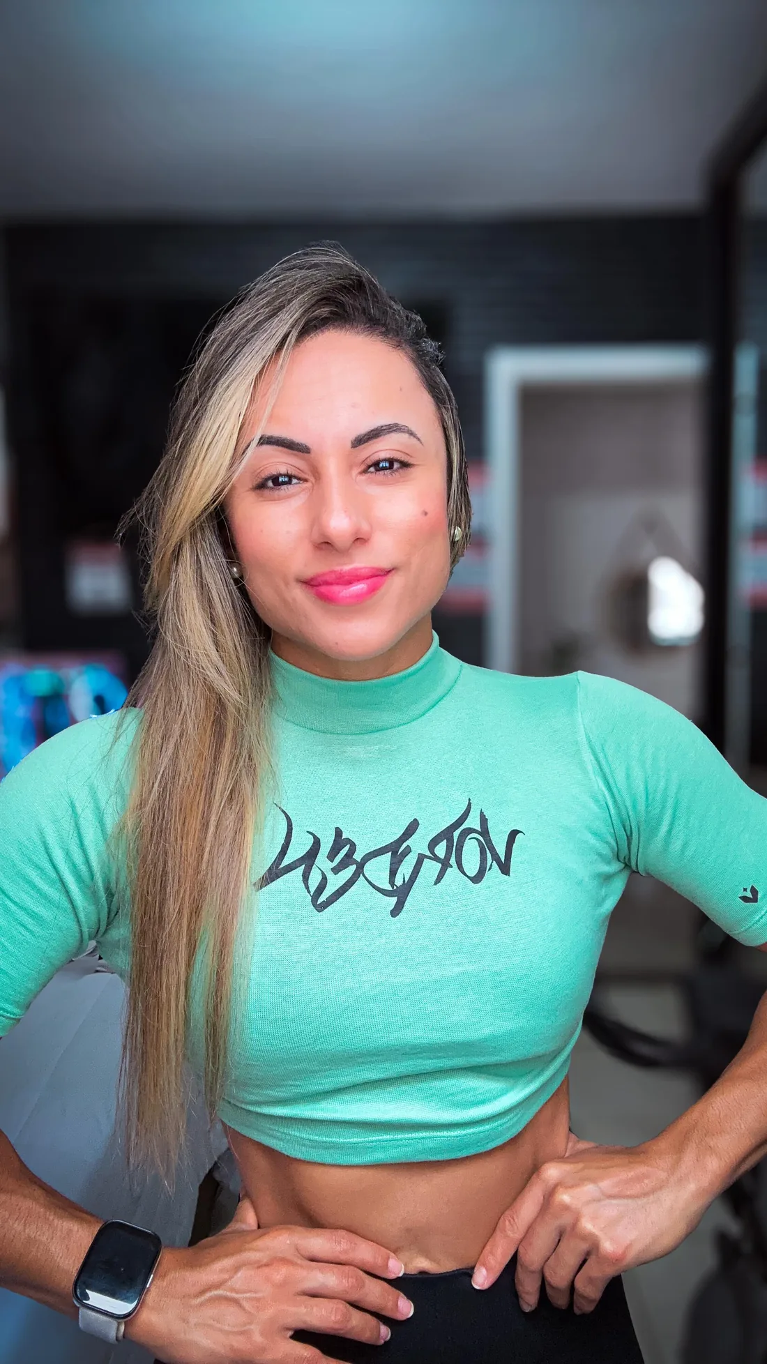Monique Ribeiro de cropped verde menta com estampa Vorden e mãos na cintura